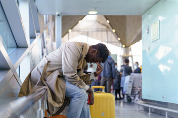 Black young man upset about the cancellation flight. Afro-American traveler male overslept his...