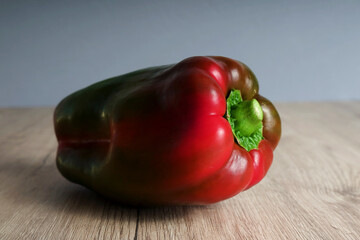 one red bell pepper on wooden table