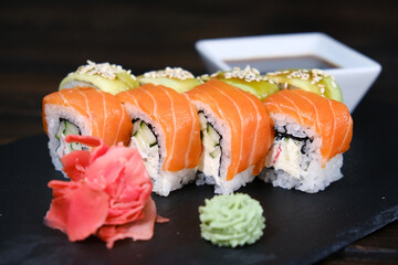 Set of Sushi Rolls with tuna, salmon, cucumber, avocado on a black table. close-up, shallow depth of field.