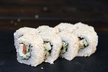 Set of Sushi Rolls with tuna, salmon, cucumber, avocado on a black table. close-up, shallow depth of field.