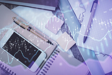 Multi exposure of forex graph hologram over desktop with phone. Top view. Mobile trade platform...