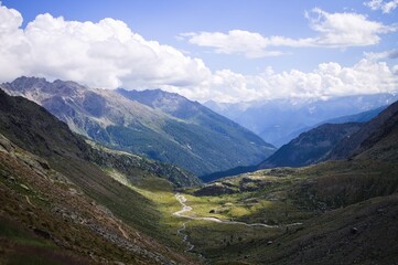 Fototapeta premium A small river surrounded by mountains in an alpine valley on the italian Alps (Trentino, Italy, Europe)
