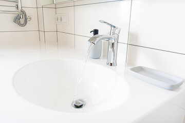 Modern bathroom detail in a luxury home, white sink and chrome tap