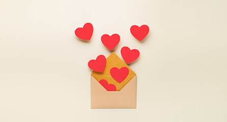 Red paper hearts fly out of paper envelope