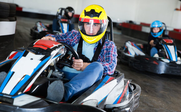 Man driving sport car for karting in a circuit lap in sport club, people on background