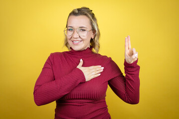Young caucasian woman wearing casual red t-shirt over yellow background smiling swearing with hand...