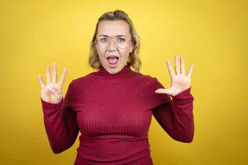 Young caucasian woman wearing casual red t-shirt over yellow background showing and pointing up...
