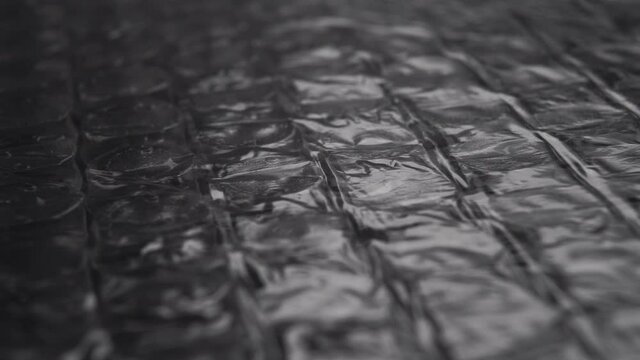 Black bubble wrap. Rows of bubbles with air close up. Macro. Dolly shot. Packaging concept