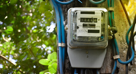 Watthour meter of electricity hung on the cement pole beside the road to monitor and measure power...