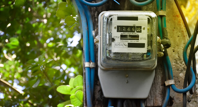 Watthour meter of electricity hung on the cement pole beside the road to monitor and measure power usage each houses in Asian countres.