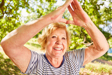 Smiling elderly woman doing a yoga exercise