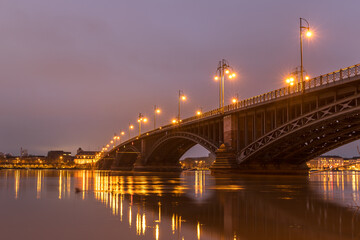 Fototapeta na wymiar Beleuchtete Brücke über den Rhein bei Mainz an einem Winterabend mit Hochwasser