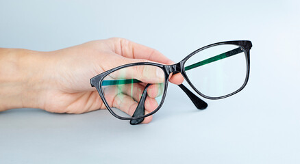 Hand Holding Black Eyeglasses