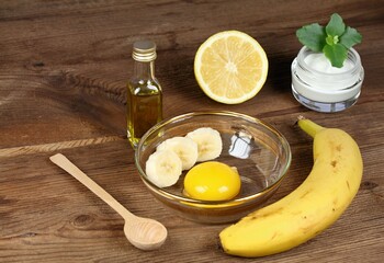 Perfect ingredients for homemade face mask, copy space. Good against wrinkles. Yolk, olive oil, banana, heavy cream and a few drops of lemon.
