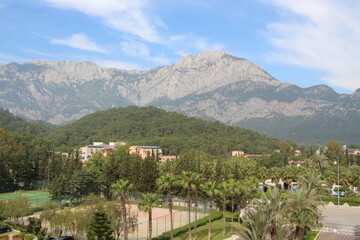 Resort landscape with mountains, greenary and tenniss court