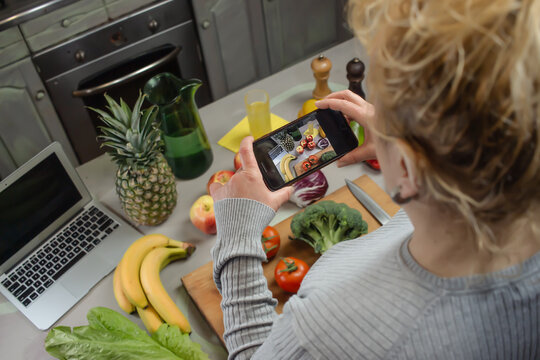 Senior woman taking picture of healthy food in the kitchen. Food blogger creating contents for her social media. Concept generation x using mobile devices. Concept healthy lifestyle of generation x.