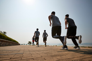 group of young asian adults running outdoors