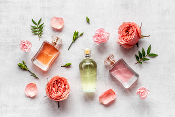 Perfume bottles with flowers and leaves, top view