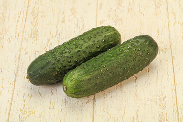 Green fresh cucumbers over background