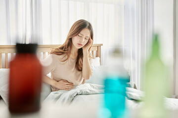 바이러스 감기로 침대에 앉아 있는 여자