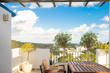 empty wooden table and chairs on the terrace in summer
