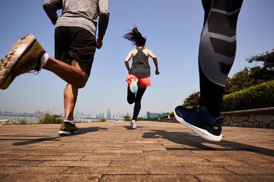 young asian adults running outdoors