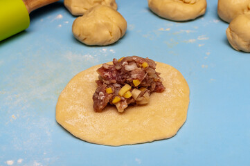 raw dough and meat filling. process of making pies or dumplings