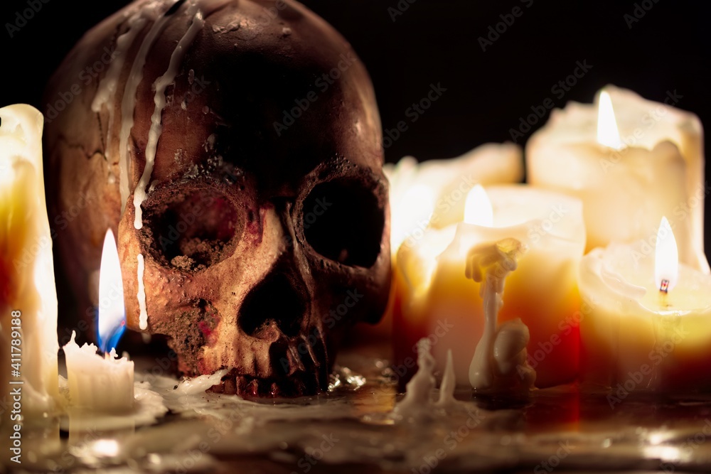 Wall mural Human skull against dark background in candle light closeup