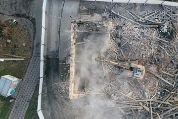 Yellow excavator destroys building. Heavy duty machine is demolishing a brick building. Demolition...