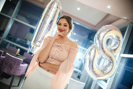 Portrait Of A Happy Brunette Female On Her Birthday Party In A Beautiful Hall With Balloons