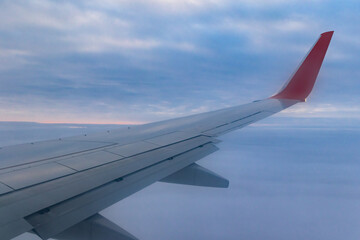 Obraz premium a view from a height above the clouds from the plane's window. part of an airplane wing in the frame