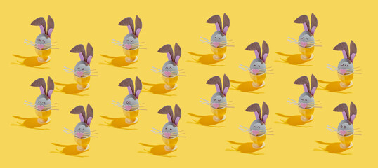 a lot of Easter eggs made as Easter bunnies with various emotions on a yellow background
