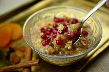 Ashure or Noah's pudding, the turkish dessert porridge in glass bowl on golden dish