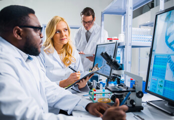 Professional team of scientists is working on a vaccine in a modern scientific research laboratory. Genetic engineer workplace. Future technology and science.