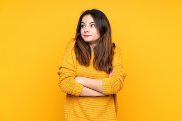 Young caucasian woman isolated on yellow background making doubts gesture while lifting the shoulders