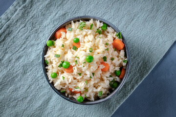 Vegan rice with vegetables, overhead shot on a blue background