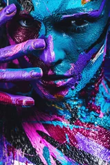 Fototapeten portrait of woman in blue and pink paint with fingers on face © Artem Popov