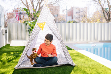 Little boy playing in a indian tent