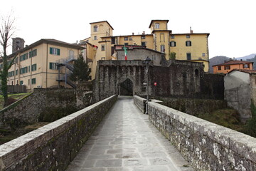 Fototapeta na wymiar The Porta Miccia or Porta di Castruccio seen from the Ponte Santa Lucia by Castruccio Castracani in the old town of Castelnuovo di Garfagnana
