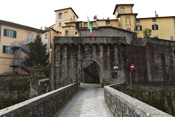 Fototapeta na wymiar The Porta Miccia or Porta di Castruccio seen from the Ponte Santa Lucia by Castruccio Castracani in the old town of Castelnuovo di Garfagnana