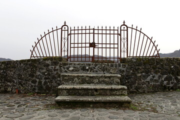 Obraz premium An old rusty gate on the walls of the fortress of Mont'Alfonso in Castelnuovo di Garfagnana, Tuscany, Italy.