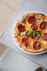 włoska pizza z salami i bazylią. 