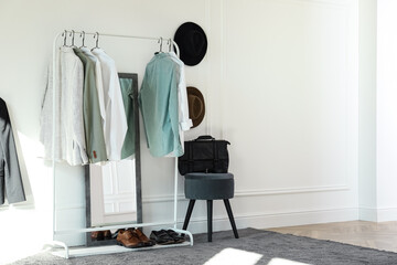 Rack with stylish clothes in modern dressing room
