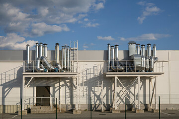 Obraz premium Outdoor metall air ducts ventilation system of a factory modern industry against blue sky