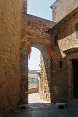 Fototapeta na wymiar Resti di mura antiche e medievali in pietra con arco