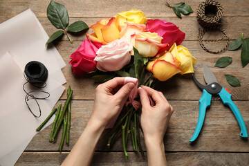 Fototapeta na wymiar Woman making luxury bouquet of fresh roses at