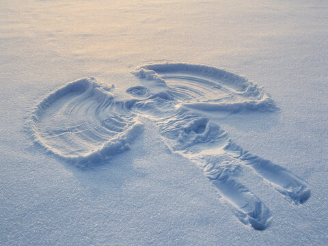 Snow angel made in the white snow. Top flat overhead view