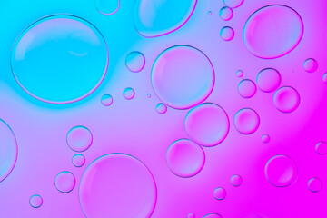 Creative neon background with drops. Glowing abstract backdrop with vibrant gradients on bubbles. Lilac, purple and blue overflowing colors