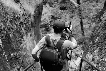 tourist with a camera in the rock town of Adrspach in the Czech Republic