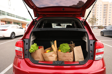 Bags full of groceries in car trunk outdoors